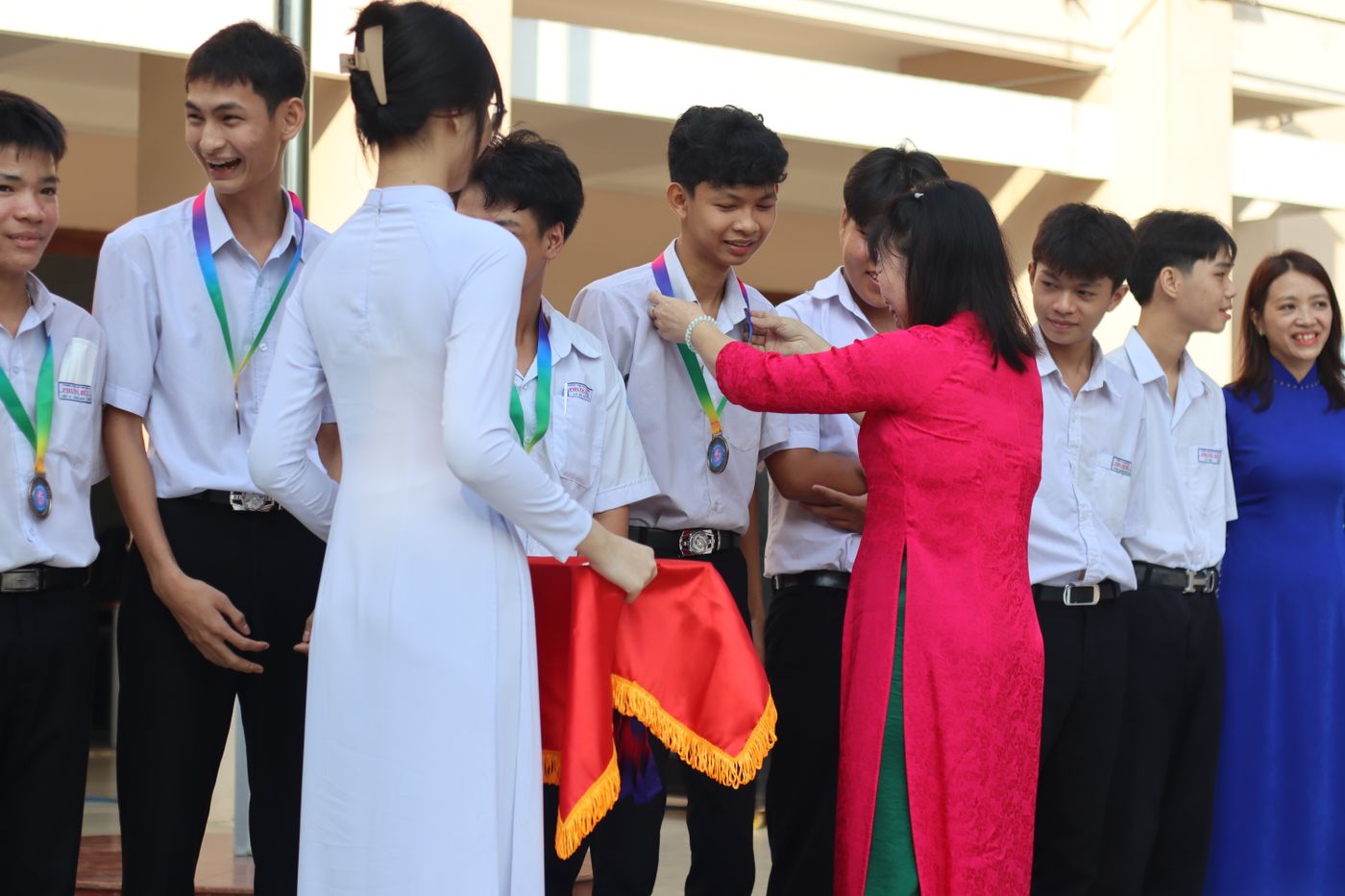 Cô giáo trong tà áo dài trao thưởng cho học sinh trong lễ tổng kết